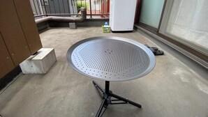 A balcony with a metal table, a white refrigerator, and a small green basket. - 1minute walk to station, direct bus to Haneda Airport! Easy access! (大田区)