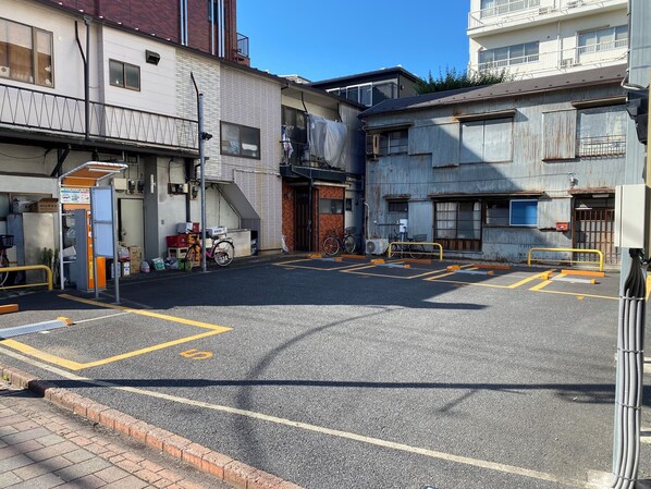 A parking lot with marked spaces, a bicycle, and a building with a staircase.