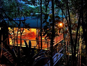 A wooden deck with railings, surrounded by trees and foliage. - Montés Samaná (San Carlos)