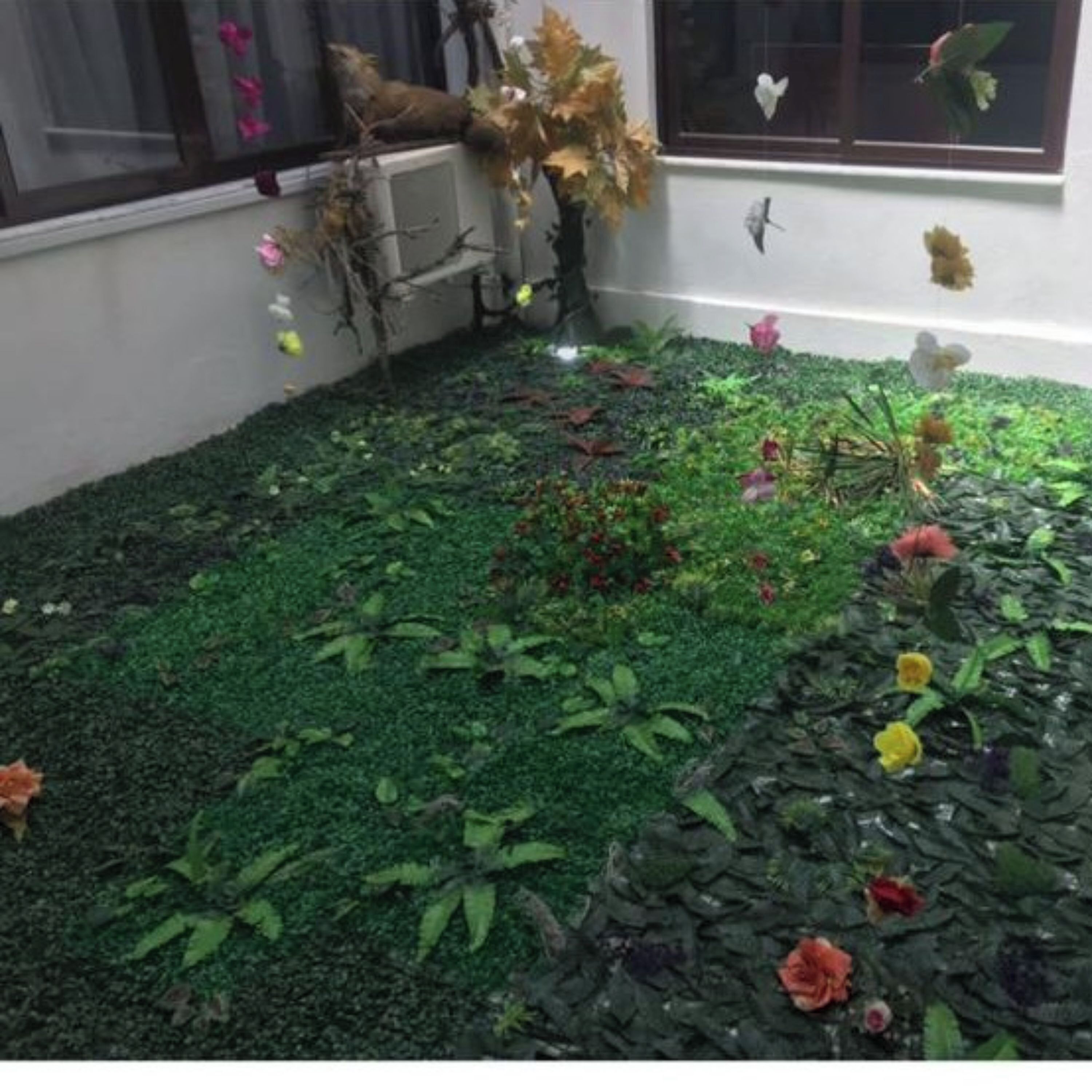 Un giardino con muschio verde, diverse piante e fiori.