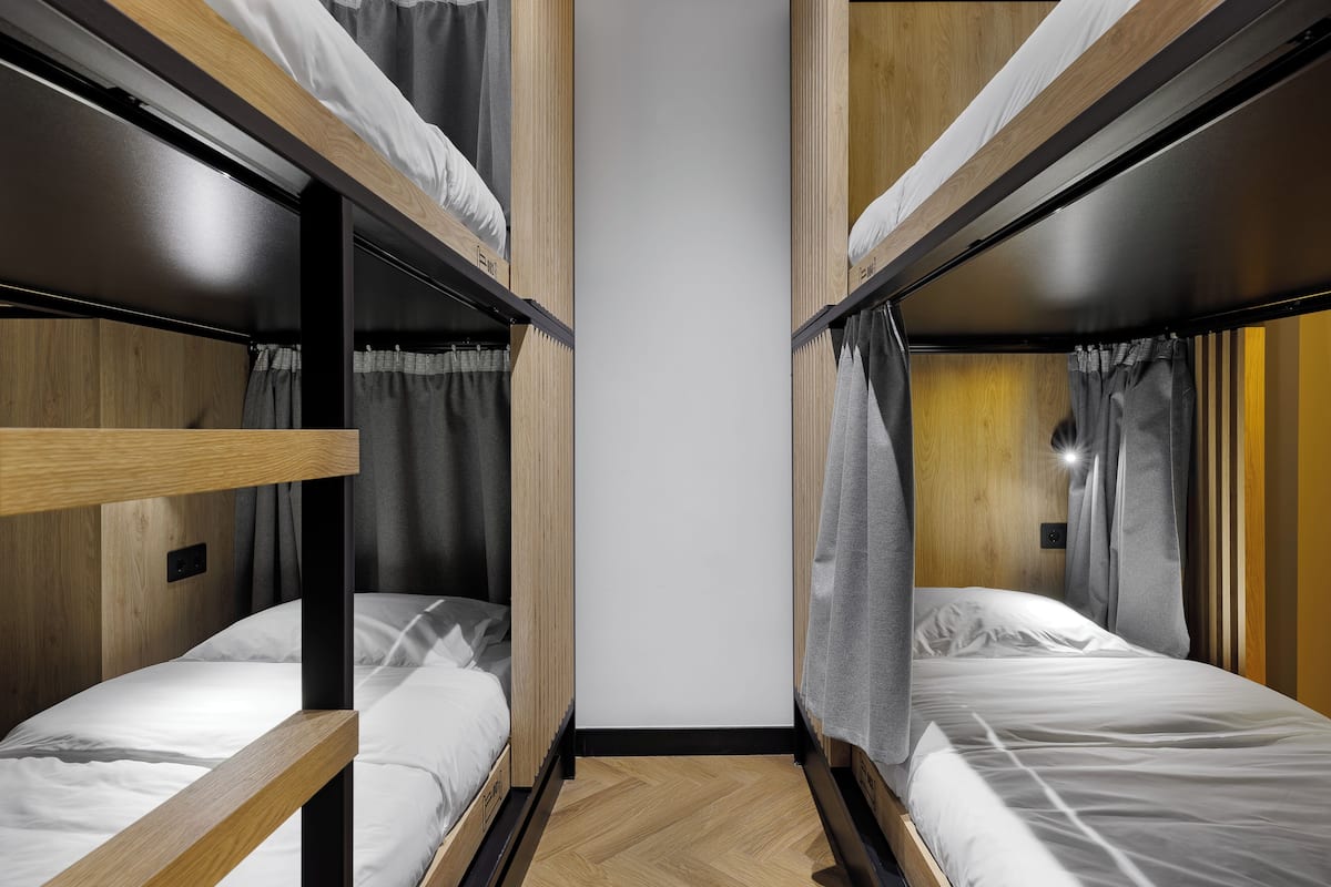 A bunk bed room with wooden walls and a white ceiling.