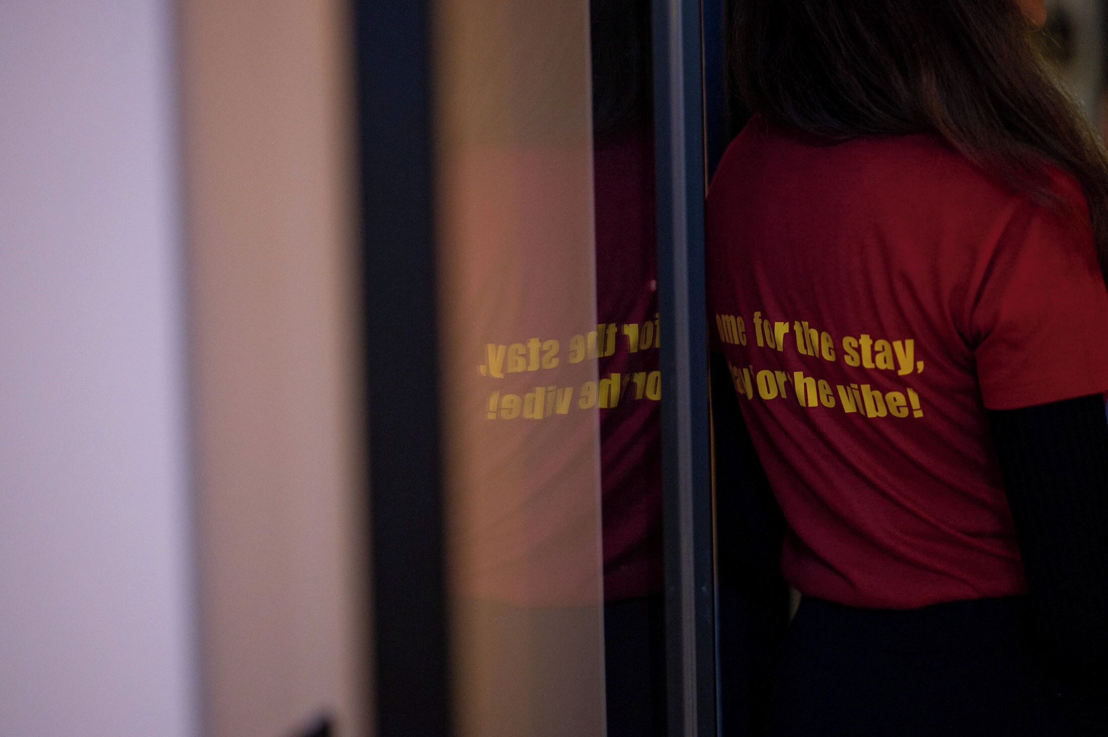 A person wearing a red shirt with yellow text.