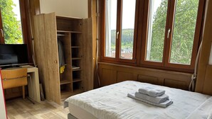 Ein Schlafzimmer mit einem Bett, einem Holzschrank und einem Fernseher.