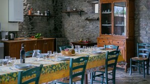 A dining area with a stone wall, wooden cabinets, and a table set for a meal. - Villa in Cortona with 8 bedrooms sleeps 16 (Cortona)