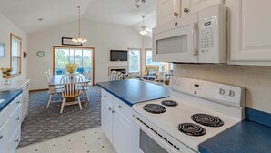 A modern kitchen with white cabinets, a blue countertop, and a built-in microwave. - Oceanside 5BR pet-friendly Corolla home with private pool & hot tub! (Corolla)