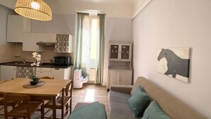 Um espaço compacto com cozinha compacta, área de refeições e sofá.