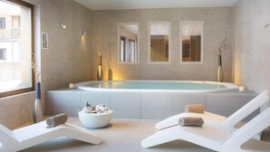 A modern spa room with a large hot tub, two lounge chairs, and a small table with toiletries. - Wifi, view mountain, swimming pool, hammam, tv, ski locker, 40-46m², Arêches-Beaufort (Beaufort)