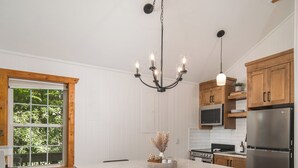 Een moderne keuken met een groot kookeiland, houten kastjes en roestvrijstalen apparatuur.