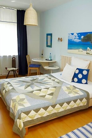 A bedroom with a large bed, a chair, a small table, and a painting on the wall. - Art Hotel Sonnenhof (Hanau)