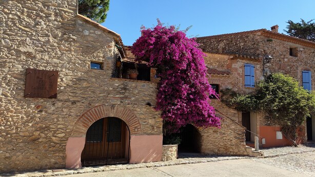 A stone building with a wooden door and a small balcony. - Chambres d'hôtes Peu del Causse SPA (Sainte-Colombe-de-la-Commanderie)