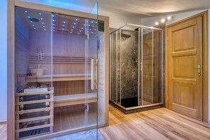 A room with a glass-enclosed walk-in closet, a shower with a glass door, and a wooden door. - Villa Dol- a Traditional Istrian house with swimming pool, jacuzzi and sauna (Buzet)