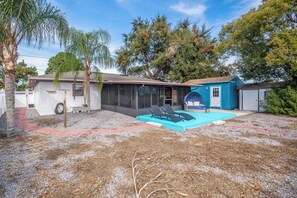 A residential property with a covered patio, a swimming pool, and a garage.