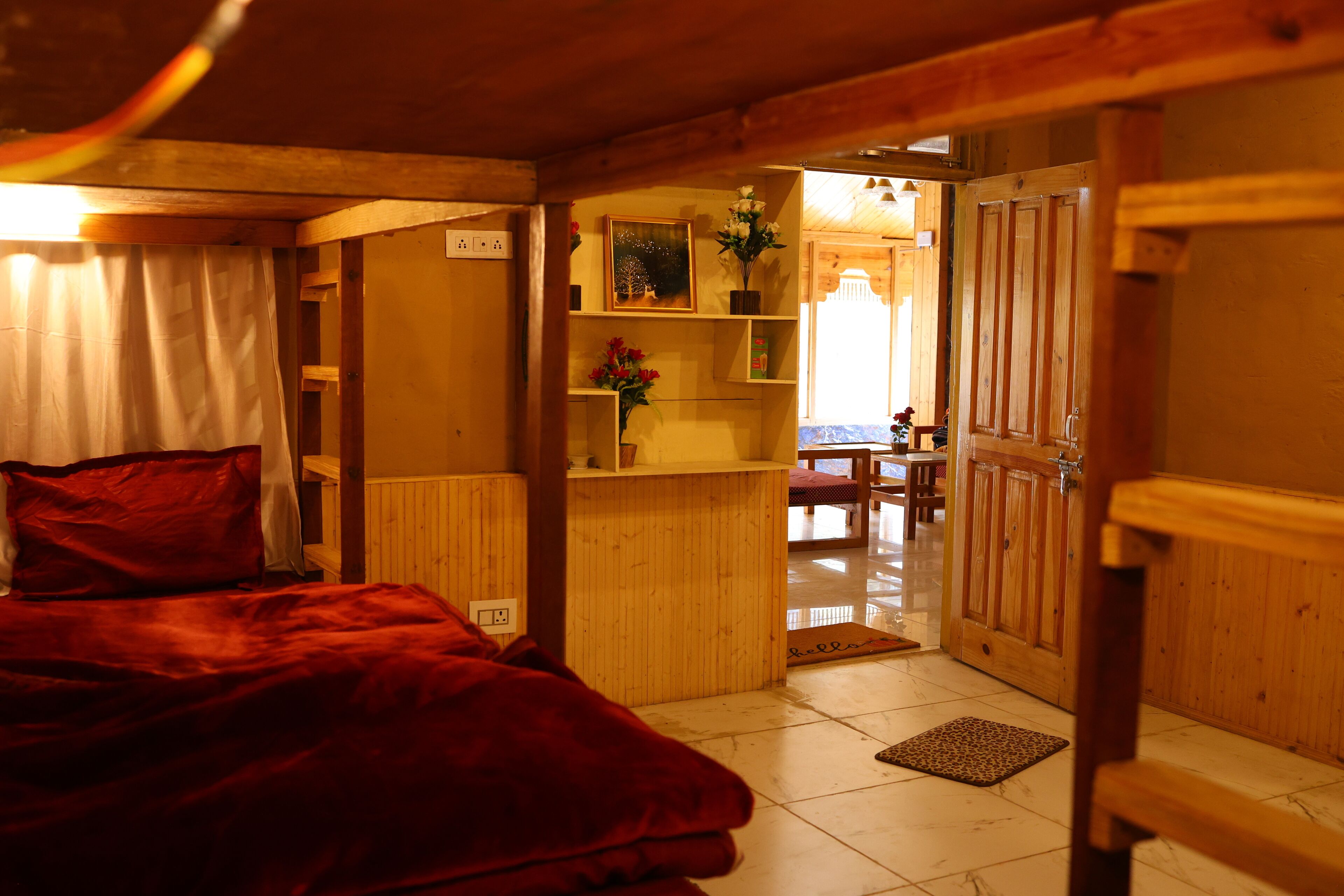 A cozy room with a bed, wooden shelves, and a door leading to another room.