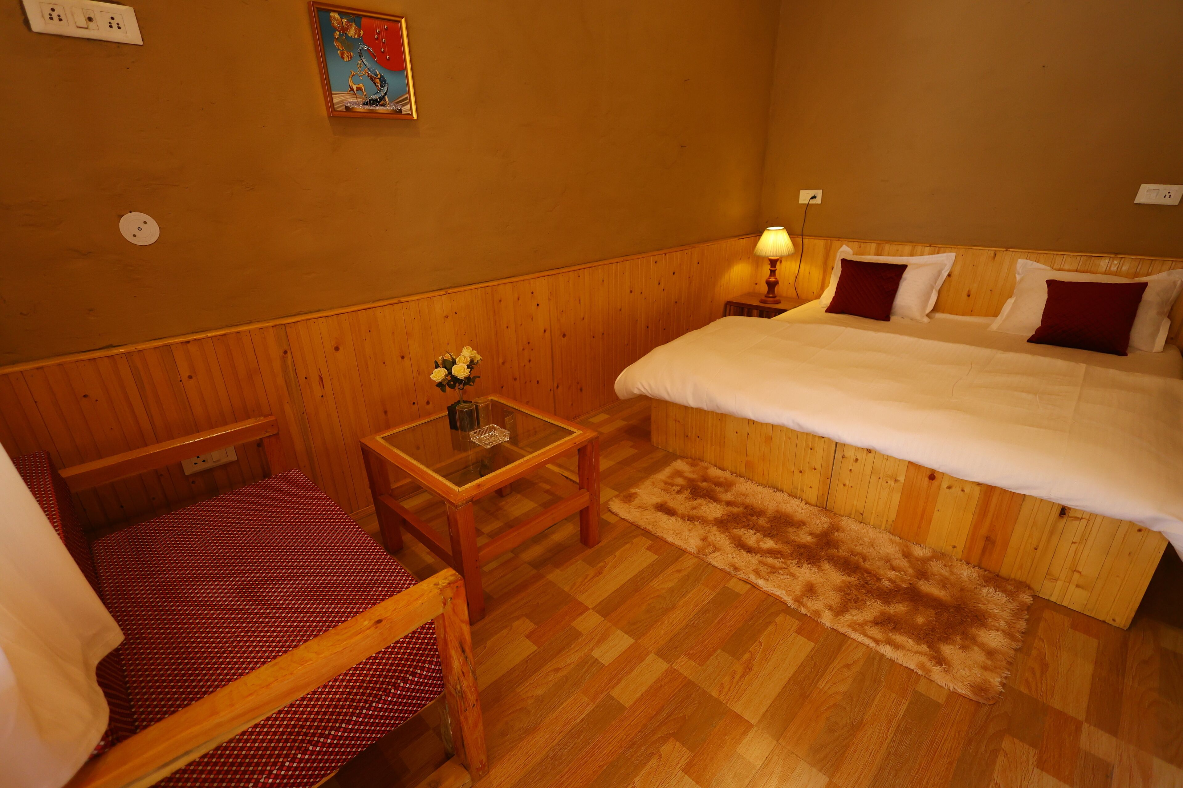 A small, cozy room with a bed, a table, and a chair.