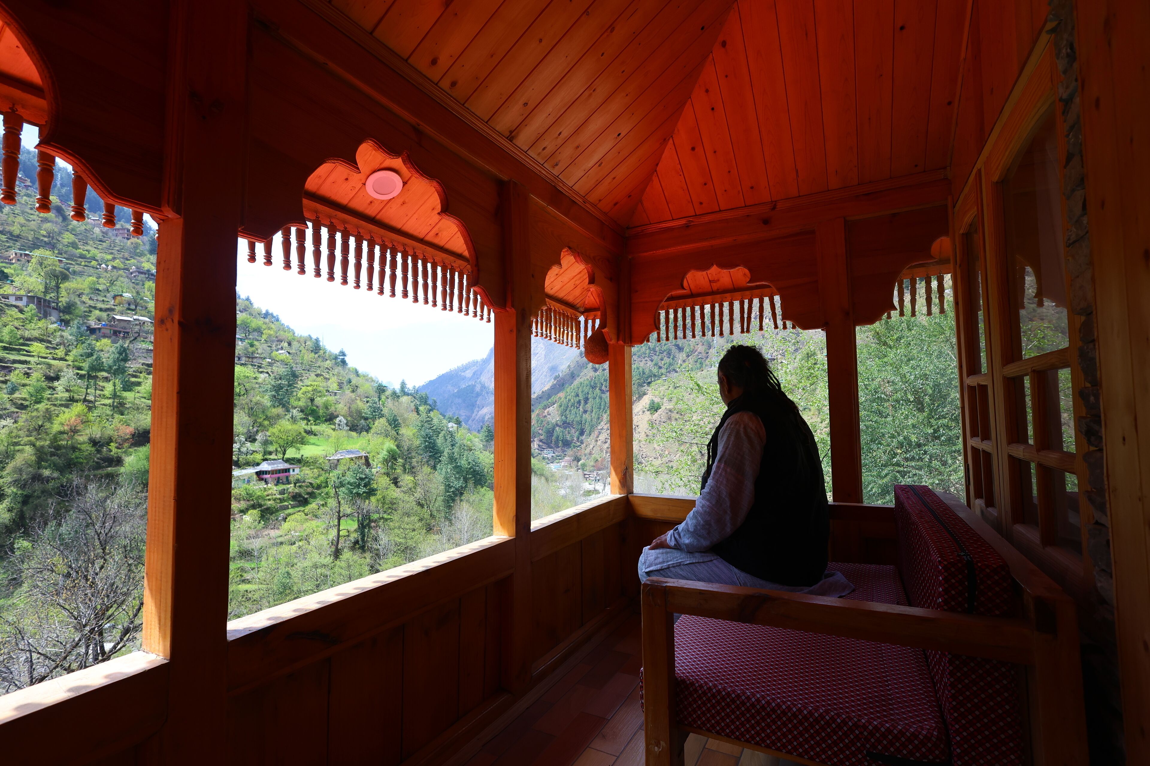 Una cabaña de madera con balcón que da a un paisaje montañoso.