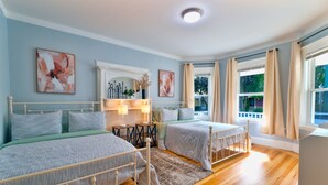 A bedroom with two beds, a fireplace, and large windows with curtains. - Renovated Retreat /Near JFK station (Boston)