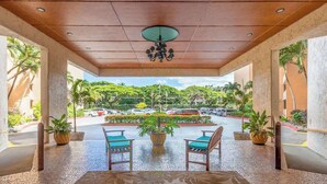 A covered outdoor seating area with a view of a parking lot and greenery.