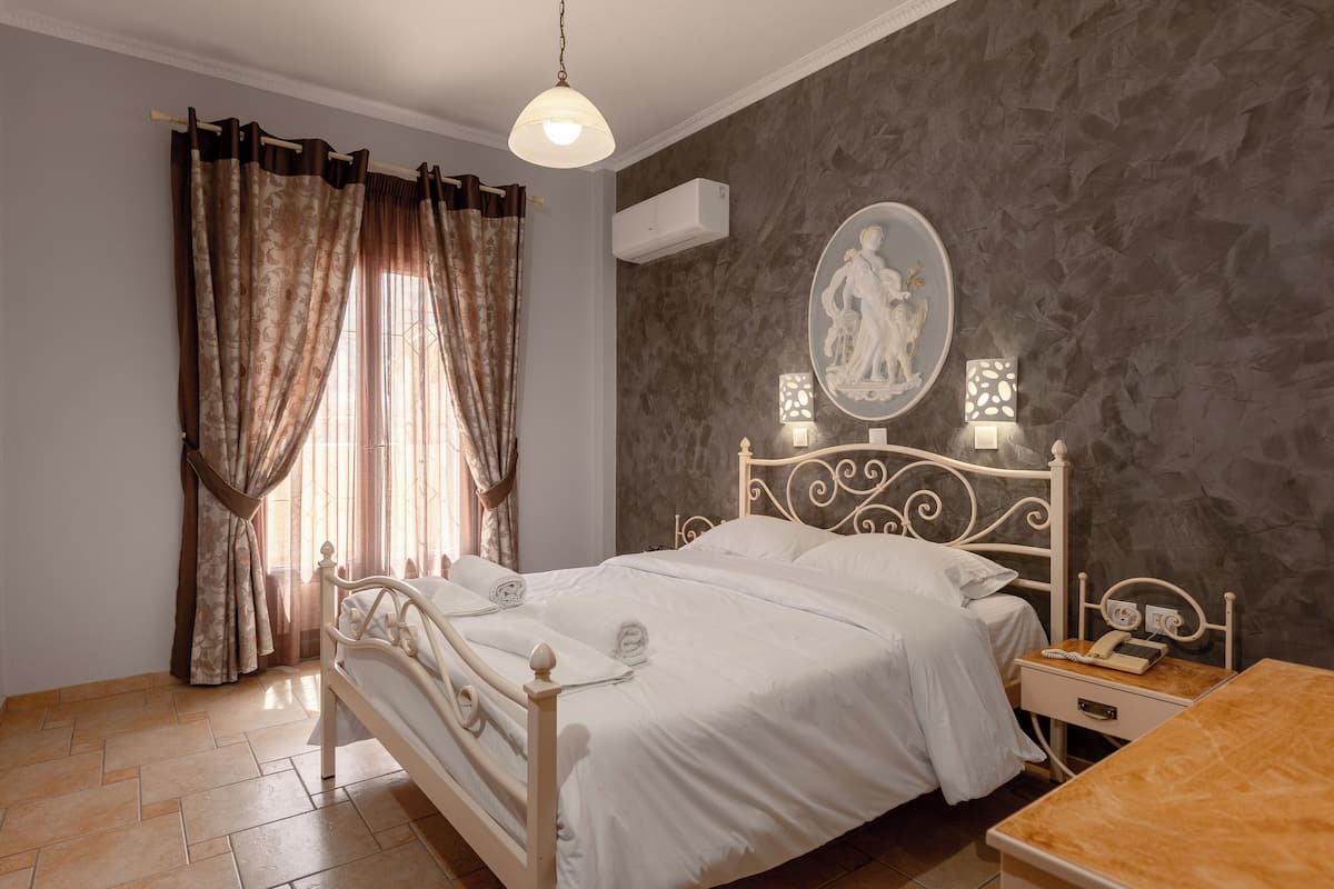A bedroom with a bed, bedside table, and a wall-mounted lamp.