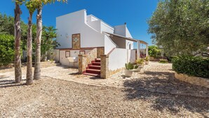 Una casa moderna con un camino de piedra que lleva a una escalera roja.
