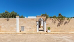 Un muro de piedra con un vano que da a un edificio.