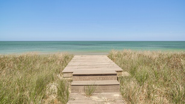 A wooden boardwalk leading to a beach with clear water and a clear sky. - Stunning Ocean View! Beachfront Nantucket Retreat (Nantucket)