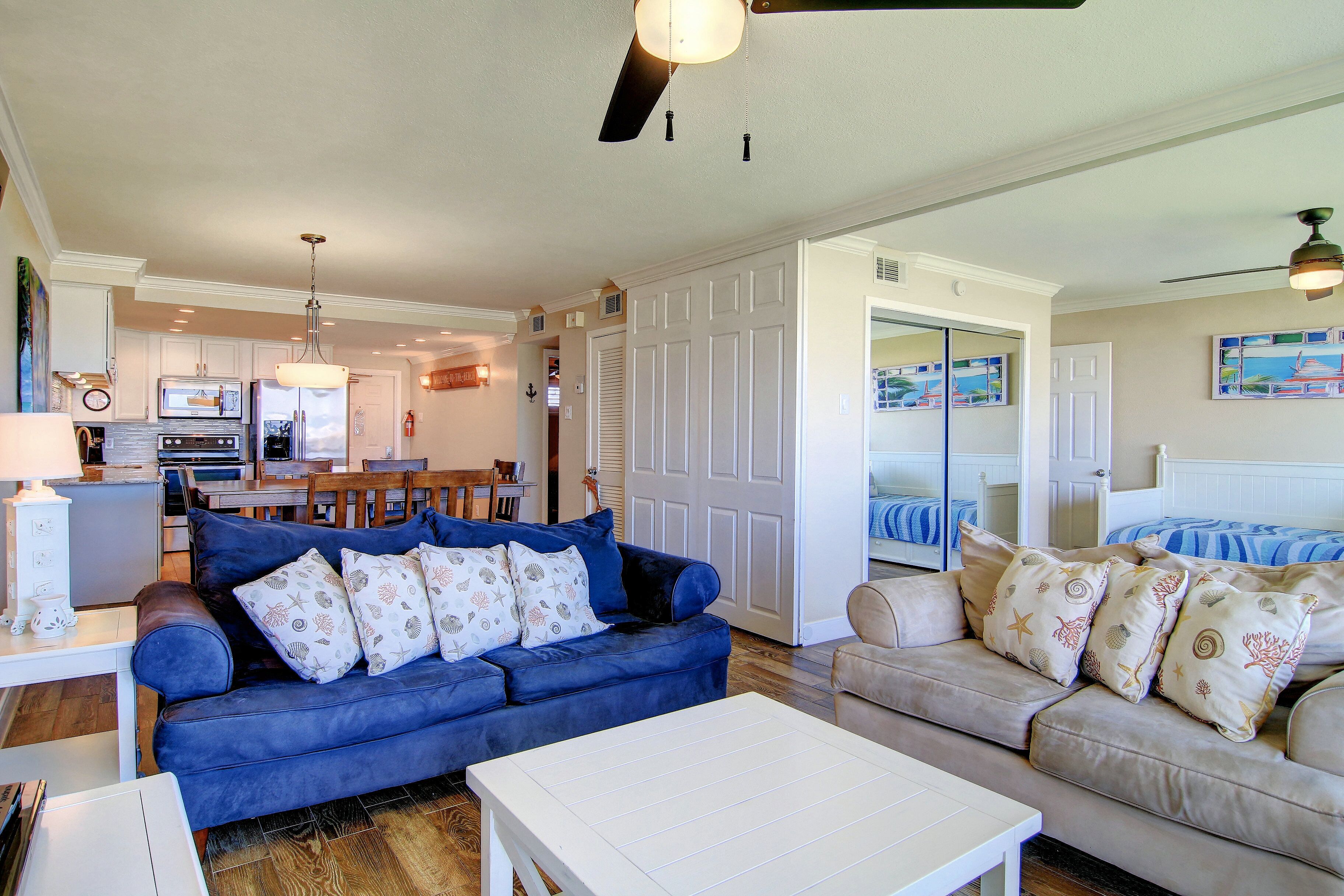 A spacious living area with two sofas, a coffee table, and a dining area with a table and chairs.