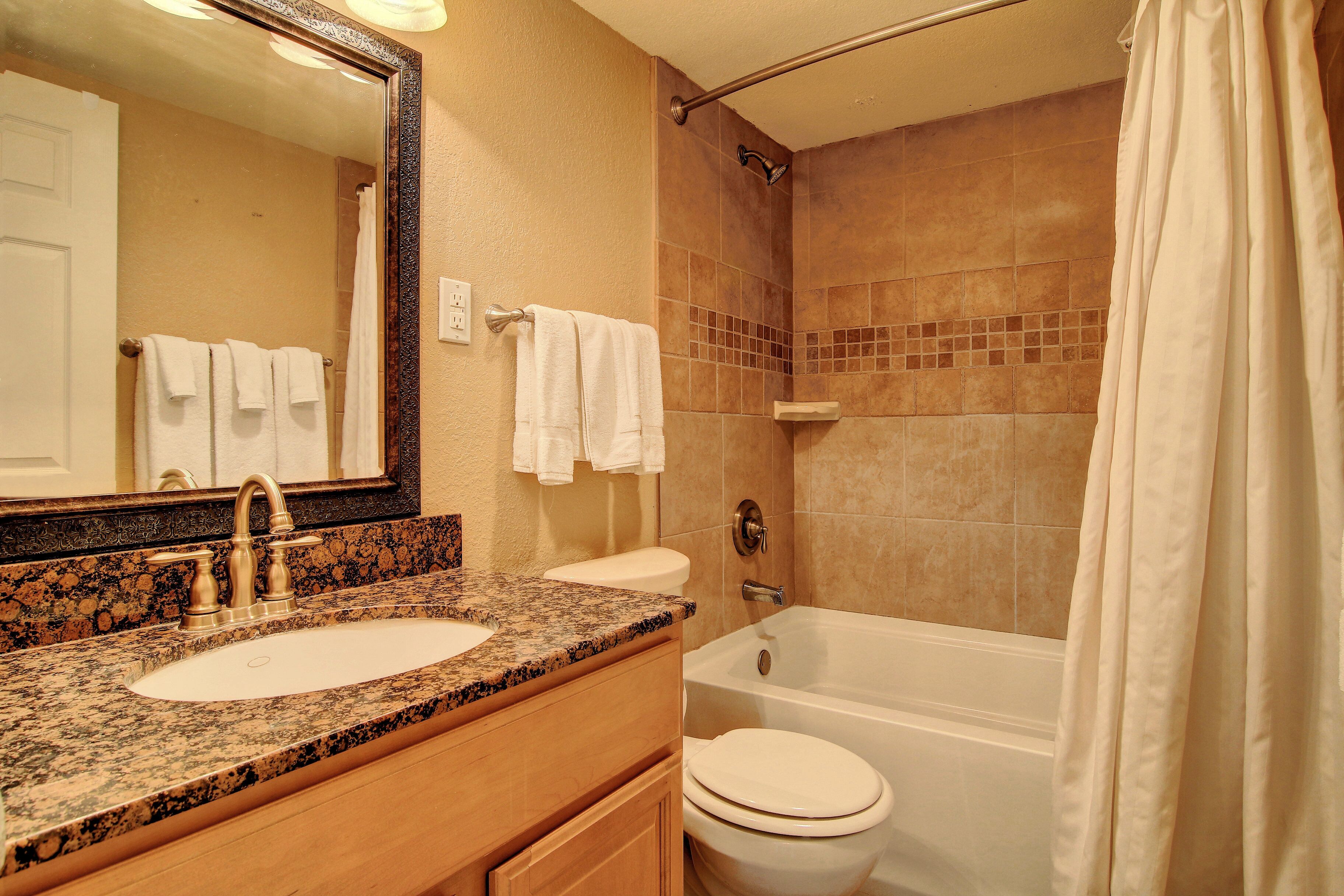 A bathroom with a sink, toilet, and bathtub.