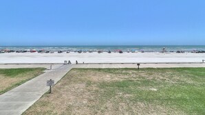 A beachside parking lot with vehicles and beach umbrellas. - Gulfstream Condos Unit 212 - Beach Front View & Balcony (Corpus Christi)
