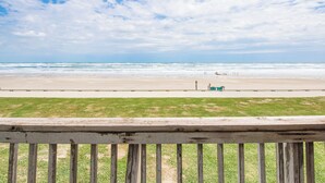 A beach view with a wooden railing in the foreground. - Gulfstream Condos Unit 216 | Direct Gulf Views | Pool, Hot Tub (Corpus Christi)