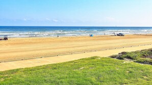 A wide sandy beach with a clear blue sky and ocean. - Gulfstream Condos Unit 217 | Gulf-Front View with Beach Balcony & Pool (Corpus Christi)