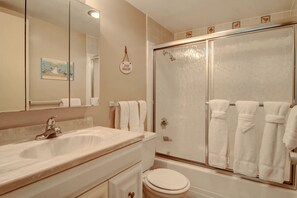 A bathroom with a sink, toilet, and glass-enclosed shower. - Gulfstream Condos Unit 301 | Extended Private Balcony | Pool, Hot Tub & BBQ (Corpus Christi)