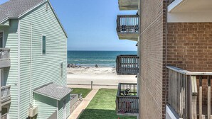 Vista de una playa desde un edificio de varios pisos con balcones que dan al océano.