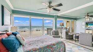 A bedroom with a large bed, a ceiling fan, a view of the beach, and a balcony with seating. - Gulfstream Condos Unit 306 | Gulf Front Views & Balcony | Pool, Hot Tub (Corpus Christi)