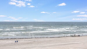 Une plage avec un rivage sablonneux et une clôture en bois.