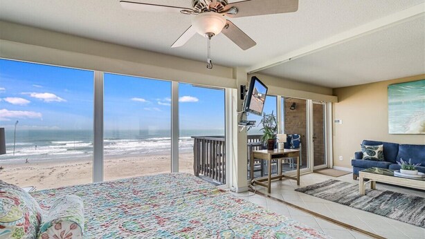 A bedroom with a large bed, a ceiling fan, and a view of the beach. - Gulfstream Condos Unit 412 | Gulf- Front View (Corpus Christi)