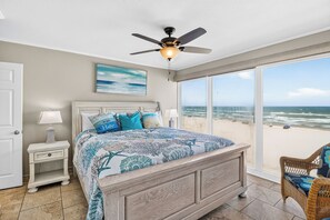 A bedroom with a large bed, a ceiling fan, a view of the beach, and a window with a view of the ocean. - Gulfstream Condos Unit 508 | Gulf Views & Beachfront Balcony | Pool, Hot Tub (Corpus Christi)