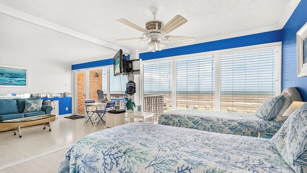 A bedroom with a bed, a ceiling fan, and a view of the beach. - Gulfstream Condos Unit 511 | Gulf-Front Balcony | Pool & Hot Tub (Corpus Christi)