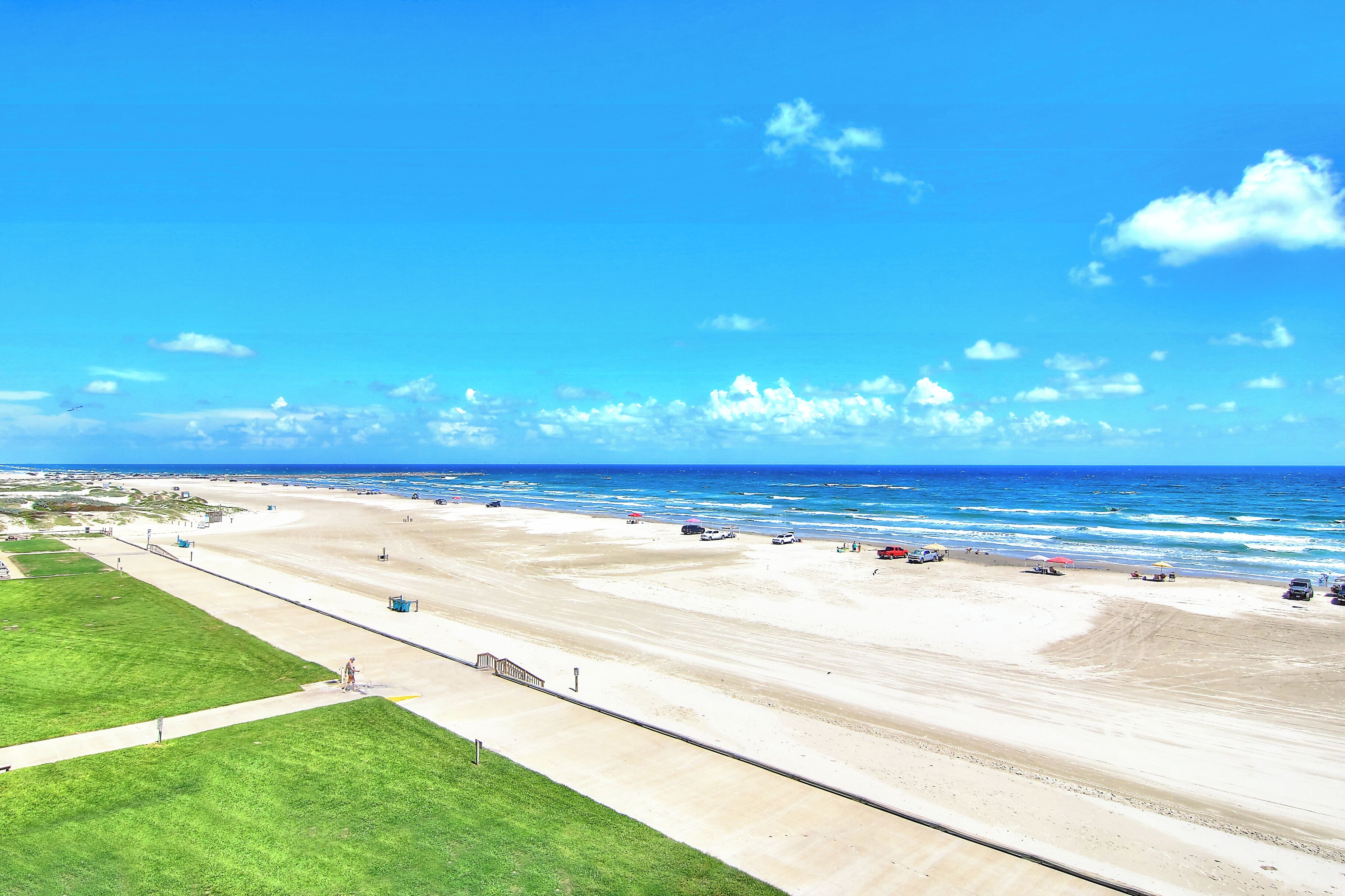 A wide beach with a clear sky and ocean.