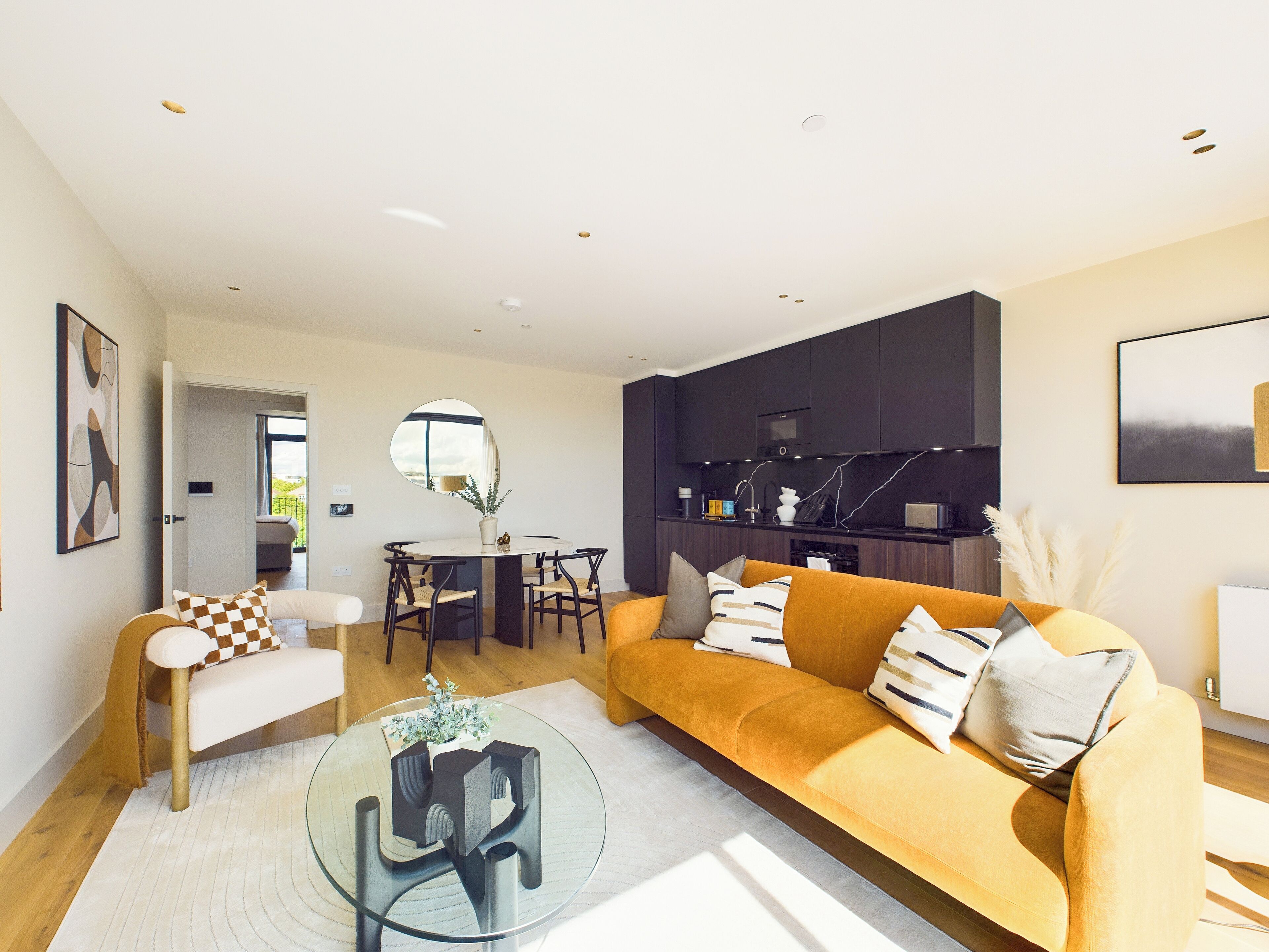 A modern living room with a sofa, coffee table, and dining area.
