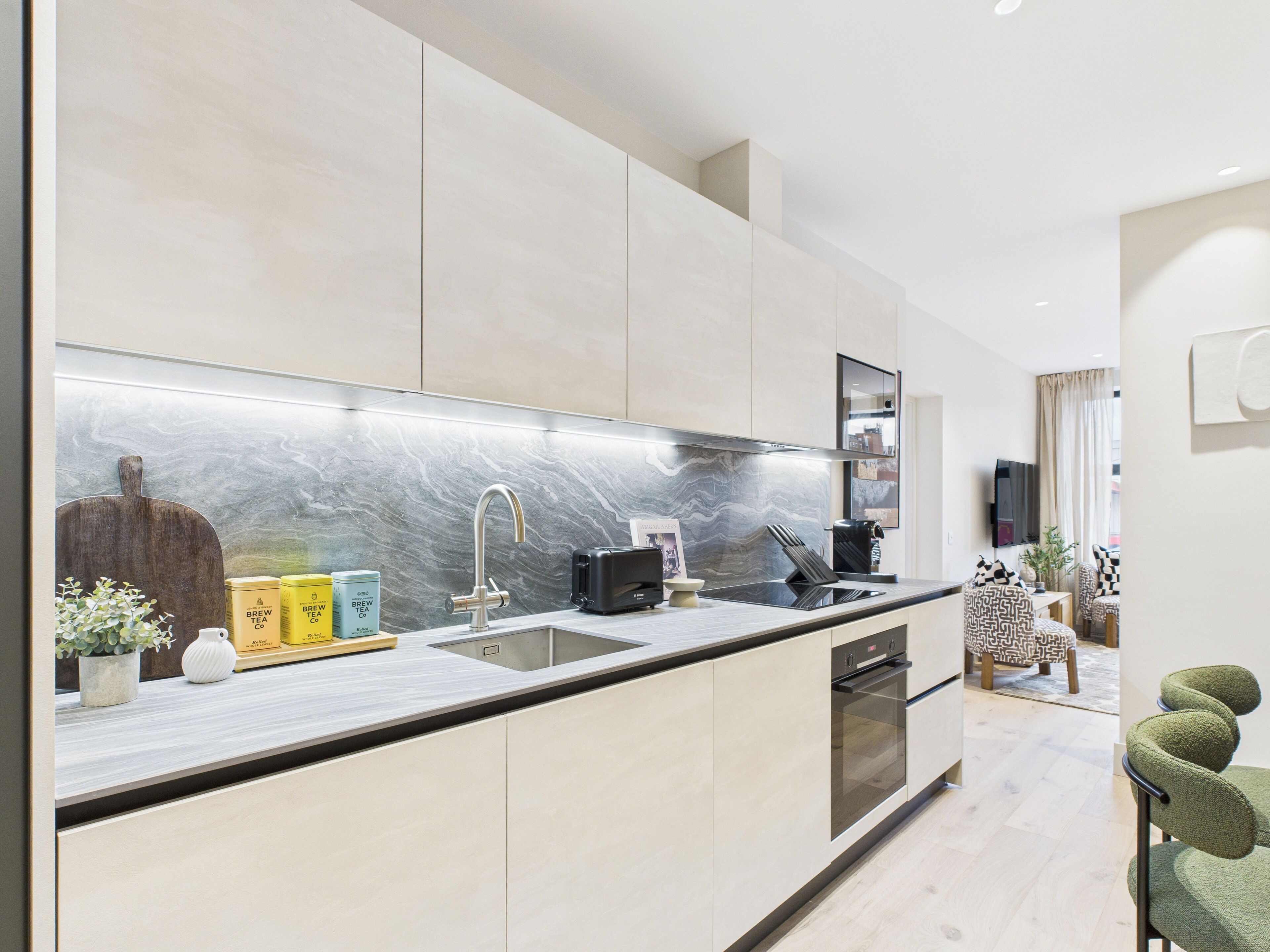 A modern kitchen with a marble backsplash, stainless steel appliances, and a minimalist design.