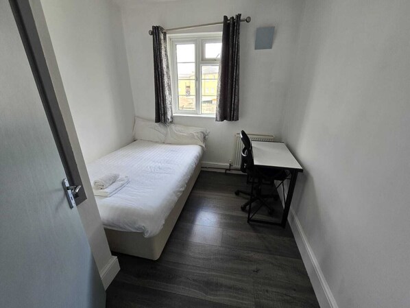 Cozy retreat with a single bed, desk, and modern amenities.