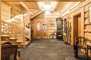 A wooden interior with a staircase, a fireplace, and a bench. - Willa Elżbiecina (Zakopane)
