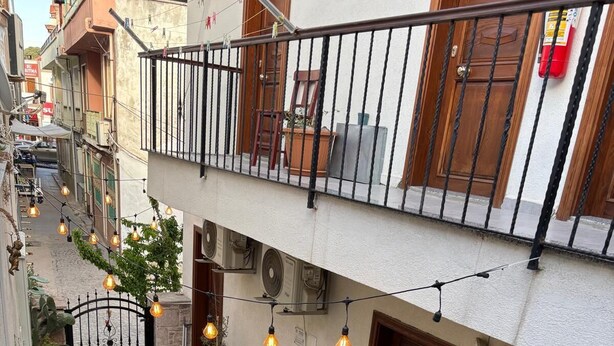 A courtyard with a table and chairs, potted plants, and a fire extinguisher. - Lokal Ayvalık (Ayvalik)