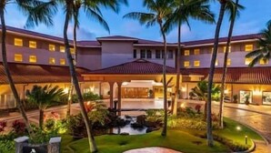 Un hôtel doté d’une cour intérieure, de palmiers et d’un élément décoratif aquatique.