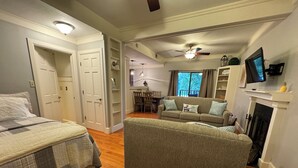 A spacious living room with a sofa, a fireplace, and a television. - Lakefront Studio Condo (Wright City)