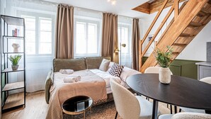 Et moderne soveværelse med seng, spisebord og trappe.
