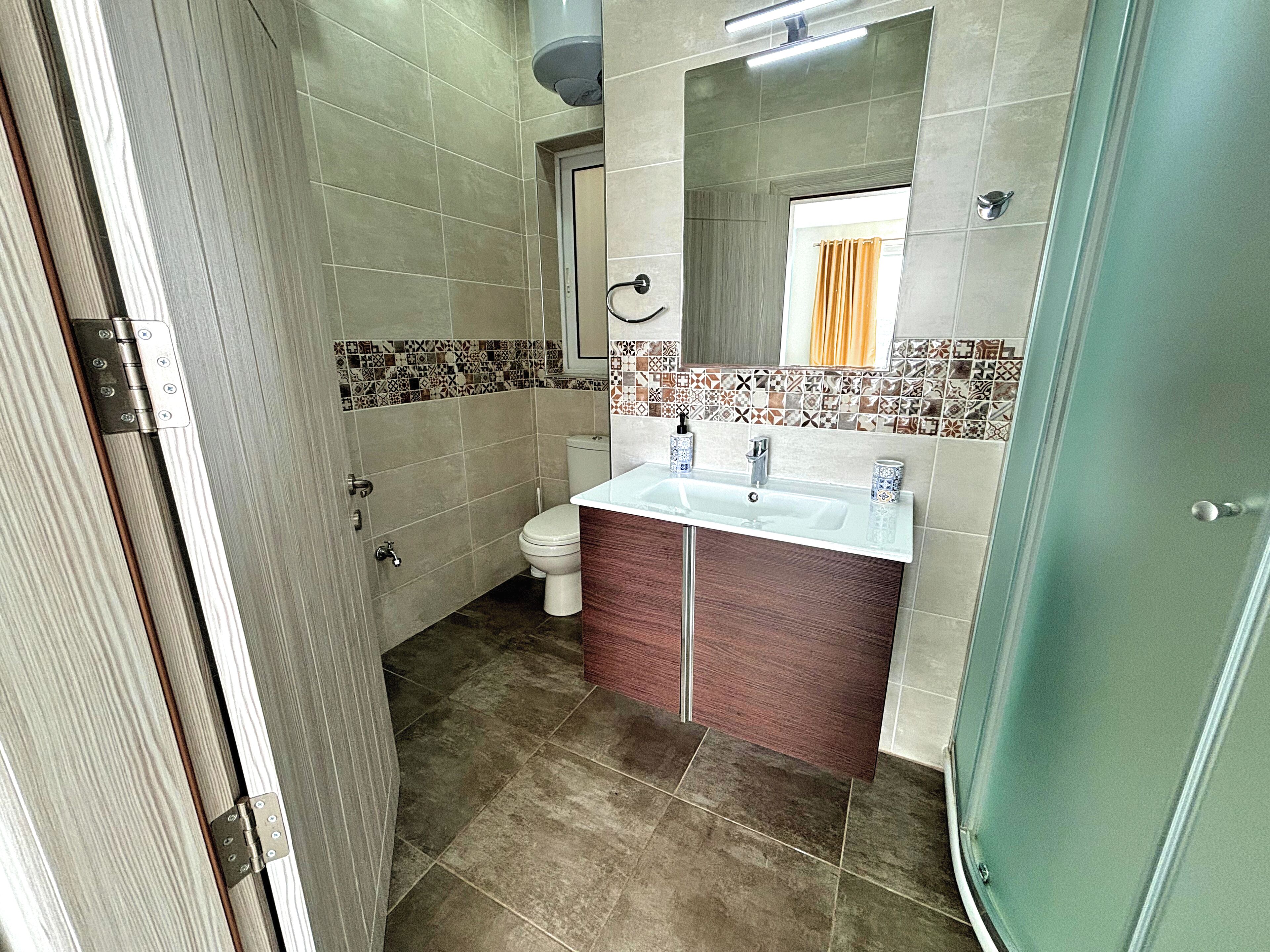 Un baño con inodoro, lavabo y ducha.