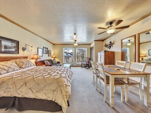 Cozy bedroom with a large bed, desk, and window offering a view of the outdoors.