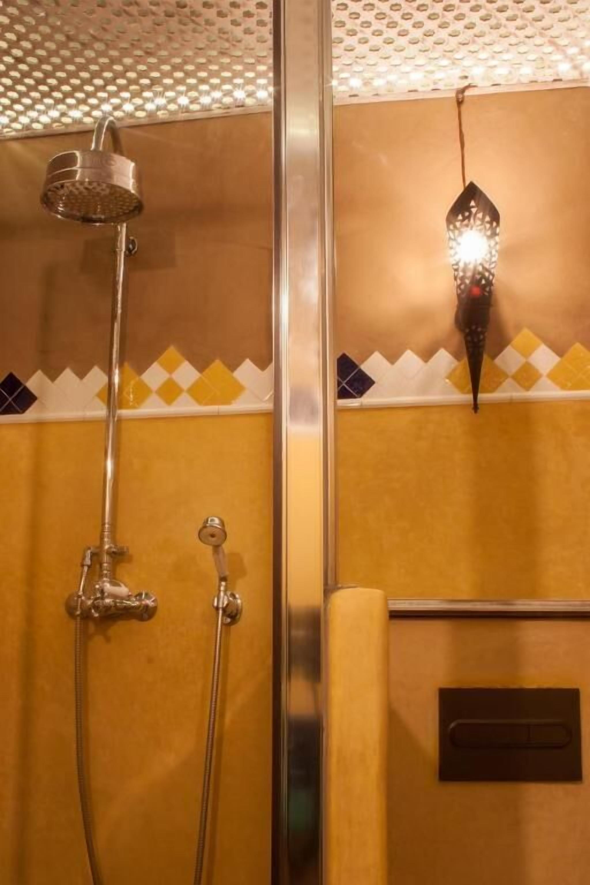 Zona de ducha con cabezal de ducha de mano e iluminación empotrada.