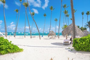 Am Strand, weißer Sandstrand, Sonnenschirme, Strandtücher